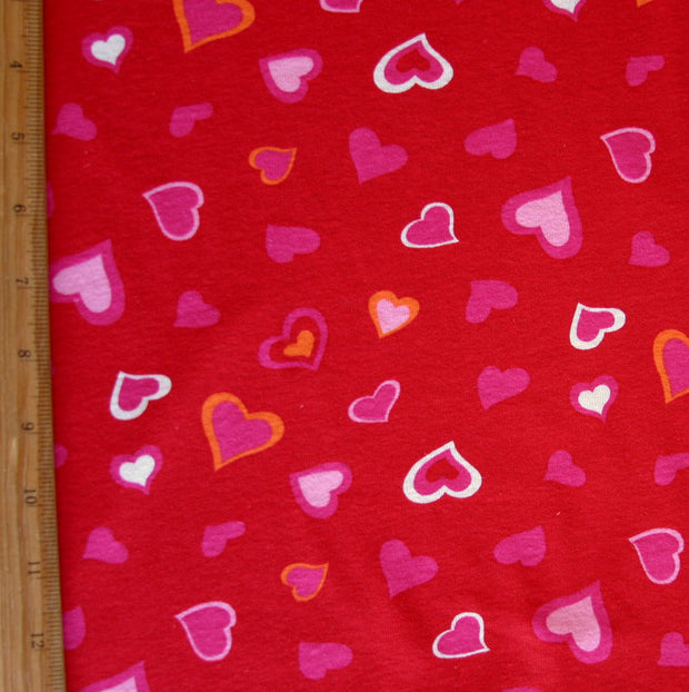 Pink, White, and Orange Hearts on Red Cotton Knit Fabric